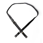 Black PU-01 faux-leather chastity belt laid flat, showing the buckle and crossed front straps