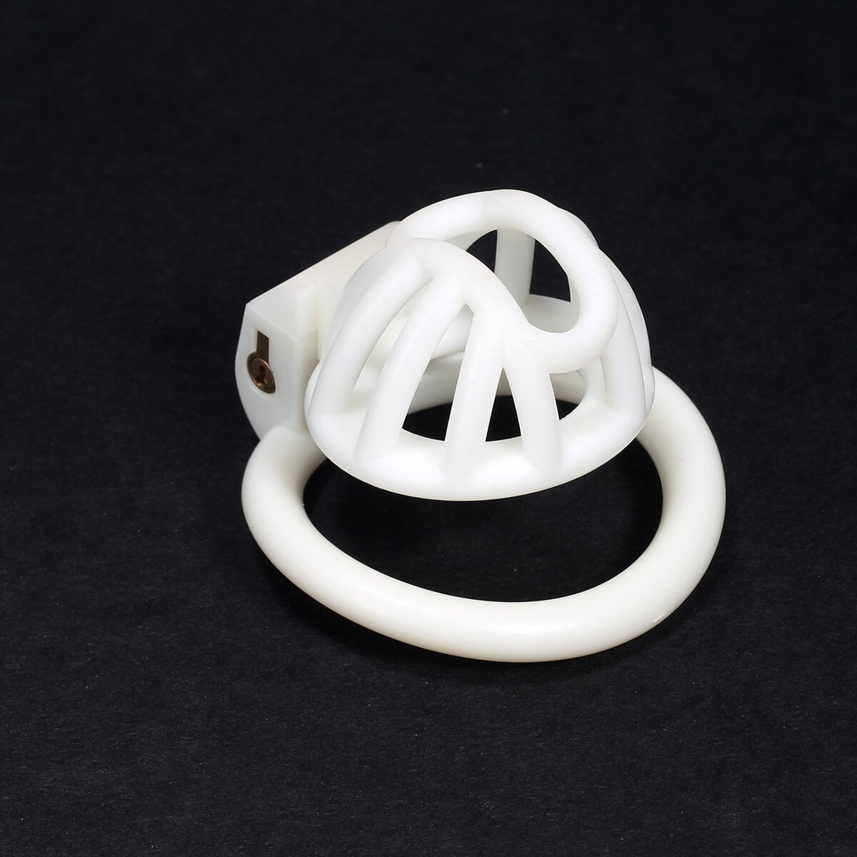 White small 3D-printed chastity cage on a dark background
