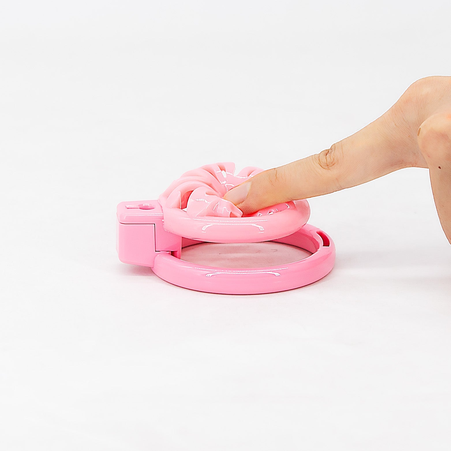 Flexible pink heart-vent chastity cage pressed flat by hand