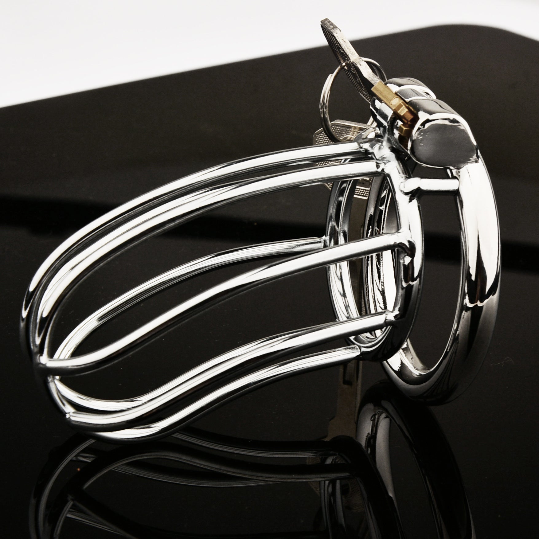 Side view of The Siebe Bonnet integrated-lock cage with keys on a black reflective surface
